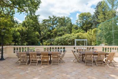 Salle de bain luxueuse avec baignoire en marbre, double vasque, miroirs, et fenêtre donnant sur un jardin.