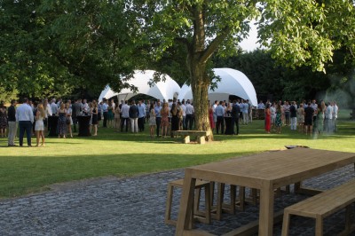 Miniature Location salle Rues-des-Vignes (Nord) - Domaine de Revelon #6 Un couple échange ses vœux sous une arche fleurie lors d'une cérémonie de mariage en plein air, entouré d'invités.