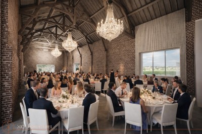 Miniature Location salle Rues-des-Vignes (Nord) - Domaine de Revelon #8 Un couple échange ses vœux sous une arche fleurie lors d'une cérémonie de mariage en plein air, entouré d'invités.