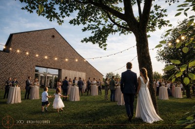 Miniature Location salle Rues-des-Vignes (Nord) - Domaine de Revelon #10 Un couple échange ses vœux sous une arche fleurie lors d'une cérémonie de mariage en plein air, entouré d'invités.