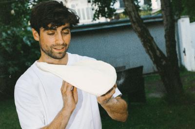 Miniature Traiteur Paris (Paris) - Pizzaiolo Tsogani #11 Un homme retire une pizza du four à l'aide d'une pelle, accompagné d'une femme souriante dans une cuisine moderne.