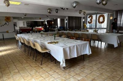 Miniature Location salle Saint-Flour (Cantal) - Salle de Réception Ander #21 Cuisine moderne avec meubles en bois clair, électroménagers, table blanche et chaises, lave-linge et sèche-linge visibles.