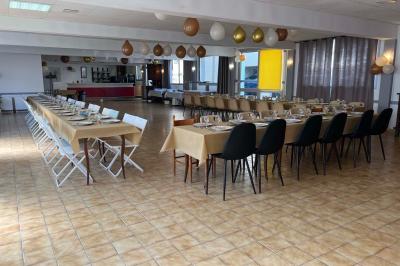 Miniature Location salle Saint-Flour (Cantal) - Salle de Réception Ander #4 Cuisine moderne avec meubles en bois clair, électroménagers, table blanche et chaises, lave-linge et sèche-linge visibles.