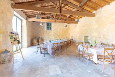 Miniature Location salle Tresses (Gironde) - Domaine de la Rose Blanche #2 Façade d'une maison en pierre avec terrasse ensoleillée, chaises longues et pots de fleurs sur un sol pavé clair.