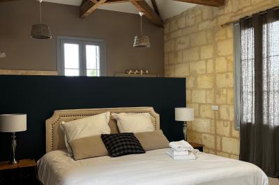 Miniature Location salle Tresses (Gironde) - Domaine de la Rose Blanche #6 Façade d'une maison en pierre avec terrasse ensoleillée, chaises longues et pots de fleurs sur un sol pavé clair.