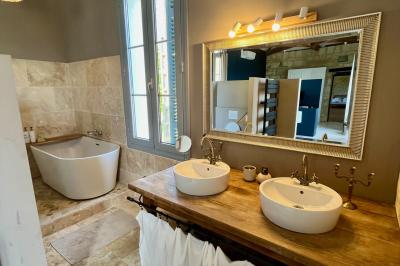 Miniature Location salle Tresses (Gironde) - Domaine de la Rose Blanche #10 Façade d'une maison en pierre avec terrasse ensoleillée, chaises longues et pots de fleurs sur un sol pavé clair.