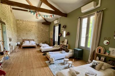 Miniature Location salle Tresses (Gironde) - Domaine de la Rose Blanche #13 Façade d'une maison en pierre avec terrasse ensoleillée, chaises longues et pots de fleurs sur un sol pavé clair.
