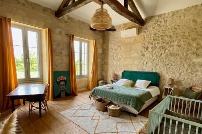 Miniature Location salle Tresses (Gironde) - Domaine de la Rose Blanche #17 Façade d'une maison en pierre avec terrasse ensoleillée, chaises longues et pots de fleurs sur un sol pavé clair.