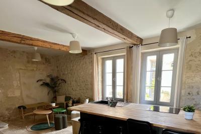 Miniature Location salle Tresses (Gironde) - Domaine de la Rose Blanche #24 Façade d'une maison en pierre avec terrasse ensoleillée, chaises longues et pots de fleurs sur un sol pavé clair.