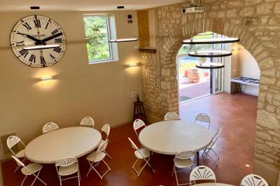 Miniature Location salle Pommiers (Rhône) - Domaine Nicolas Rebut #4 Façade d'un bâtiment en pierre avec de grandes fenêtres, une entrée vitrée et une cour en gravier sous un ciel bleu.