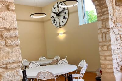 Miniature Location salle Pommiers (Rhône) - Domaine Nicolas Rebut #9 Façade d'un bâtiment en pierre avec de grandes fenêtres, une entrée vitrée et une cour en gravier sous un ciel bleu.