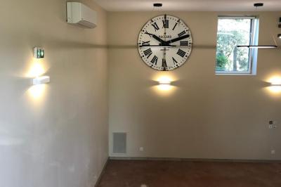 Miniature Location salle Pommiers (Rhône) - Domaine Nicolas Rebut #10 Façade d'un bâtiment en pierre avec de grandes fenêtres, une entrée vitrée et une cour en gravier sous un ciel bleu.