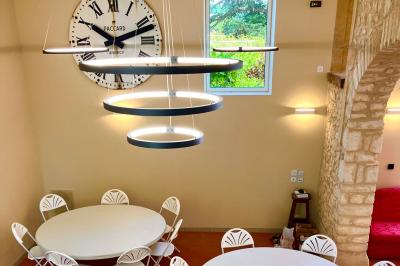 Miniature Location salle Pommiers (Rhône) - Domaine Nicolas Rebut #7 Façade d'un bâtiment en pierre avec de grandes fenêtres, une entrée vitrée et une cour en gravier sous un ciel bleu.