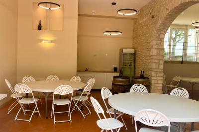 Miniature Location salle Pommiers (Rhône) - Domaine Nicolas Rebut #6 Façade d'un bâtiment en pierre avec de grandes fenêtres, une entrée vitrée et une cour en gravier sous un ciel bleu.