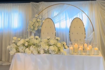 Miniature Deco Events #3 Salle de réception élégante avec tables rondes décorées de nappes blanches, chaises dorées et centres de table fleuris.