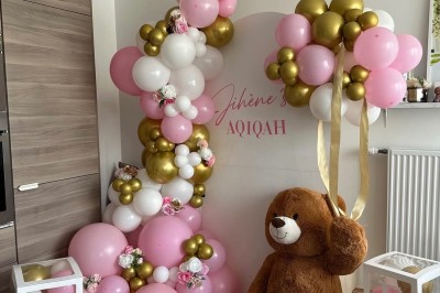 Miniature Deco Events #7 Salle de réception élégante avec tables rondes décorées de nappes blanches, chaises dorées et centres de table fleuris.