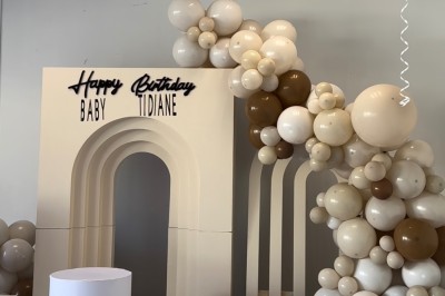 Miniature Deco Events #8 Salle de réception élégante avec tables rondes décorées de nappes blanches, chaises dorées et centres de table fleuris.