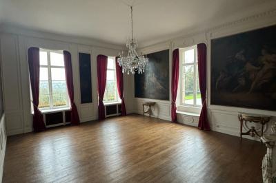 Miniature Location salle Grez-Doiceau (Brabant wallon) - Château de Laurensart #5 Salle élégante avec un lustre imposant, table ronde en bois, chaises vertes et grandes fenêtres encadrées de rideaux.