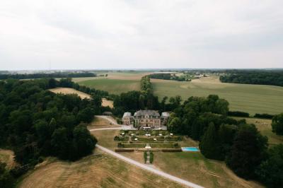 Miniature Location salle Grez-Doiceau (Brabant wallon) - Château de Laurensart #2 Une mariée en robe longue marche aux côtés d'un homme en costume sur une terrasse avec vue sur un paysage verdoyant.