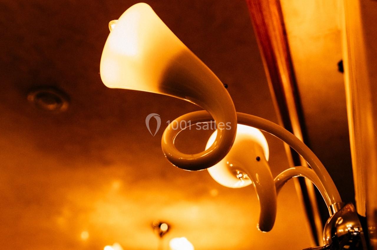 Lampe murale au design courbé, éclairant une pièce avec une lumière chaude et tamisée.