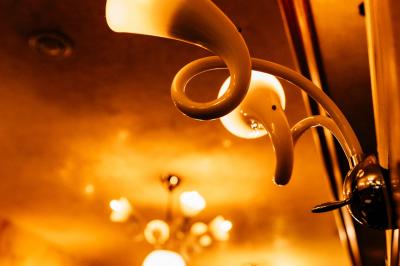 Salle de restaurant avec tables dressées, banquettes en bois, bar en bois et étagères garnies de verres et bouteilles.