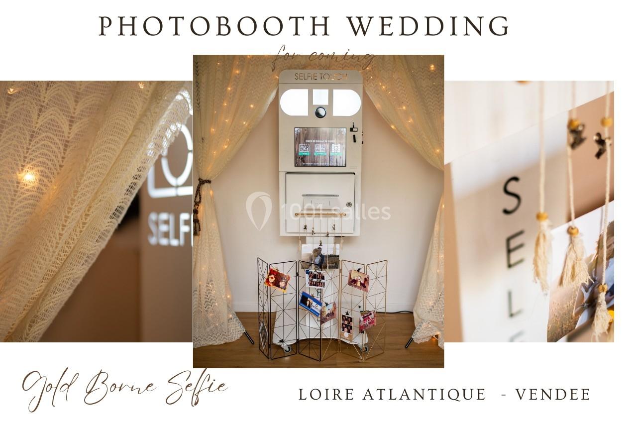 Borne photo installée entre des rideaux en dentelle, avec des photos suspendues sur un présentoir métallique.