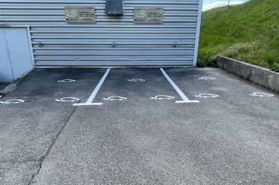 Salle de réception avec une longue table dressée, des chaises rouges et noires, et une fresque murale représentant un…