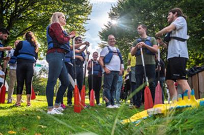 Salle élégante avec tables rondes dressées pour un repas, décorée de rideaux dorés, miroirs et mobilier classique.