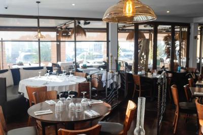 Miniature Location salle Rungis (Val-de-Marne) - Les Embruns #3 Plantes en pot sur une terrasse couverte avec des tables dressées et des chaises en osier.