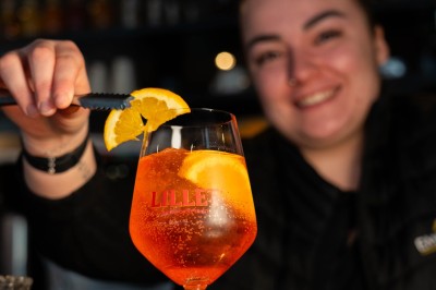 Desserts variés sur une table, incluant un tiramisu décoré d'une tranche d'orange, une mousse au chocolat et un cappuccino.