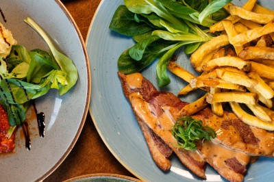 Desserts variés sur une table, incluant un tiramisu décoré d'une tranche d'orange, une mousse au chocolat et un cappuccino.