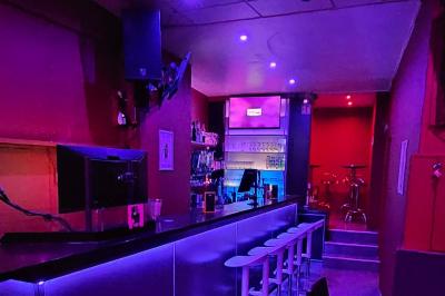 Miniature Location salle Bruxelles (Bruxelles-Capitale) - Karaoke Bar Sablon #3 Écran et panneau indiquant ’Karaoké Bar Sablon’ avec un micro, dans une salle éclairée par des lumières violettes.