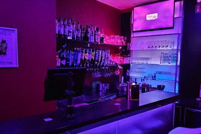 Miniature Location salle Bruxelles (Bruxelles-Capitale) - Karaoke Bar Sablon #5 Écran et panneau indiquant ’Karaoké Bar Sablon’ avec un micro, dans une salle éclairée par des lumières violettes.