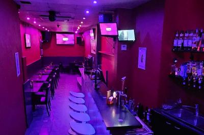 Miniature Location salle Bruxelles (Bruxelles-Capitale) - Karaoke Bar Sablon #2 Écran et panneau indiquant ’Karaoké Bar Sablon’ avec un micro, dans une salle éclairée par des lumières violettes.