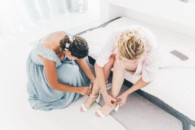 Salle de réception élégante avec tables dressées, chaises blanches et décorations florales sous un éclairage chaleureux.