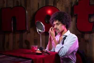 Salle de réception élégante avec tables dressées, chaises blanches et décorations florales sous un éclairage chaleureux.