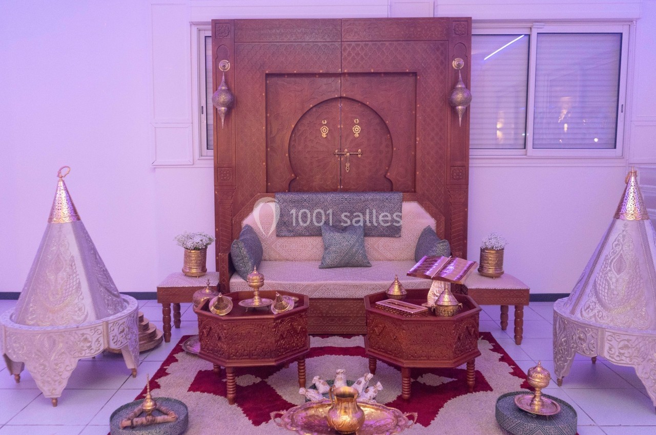 Salon décoré dans un style traditionnel avec mobilier en bois sculpté, tables basses et accessoires dorés.