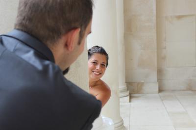 Un couple de mariés échange un regard complice devant l'autel d'une église ornée de bois sculpté.