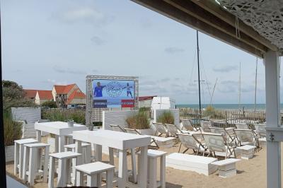 Écran géant installé en extérieur diffusant un match de football, avec une plage visible en arrière-plan.