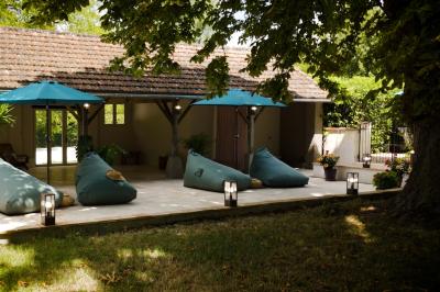 Miniature LA TERRASSE DU PAVILLON Chambre lumineuse avec lit double, fauteuil en bois, baignoire blanche et grande fenêtre donnant sur l'extérieur.