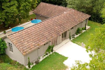 Miniature LE PAVILLON Chambre lumineuse avec lit double, fauteuil en bois, baignoire blanche et grande fenêtre donnant sur l'extérieur.