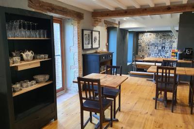 Miniature PETIT DEJEUNER Chambre lumineuse avec lit double, fauteuil en bois, baignoire blanche et grande fenêtre donnant sur l'extérieur.