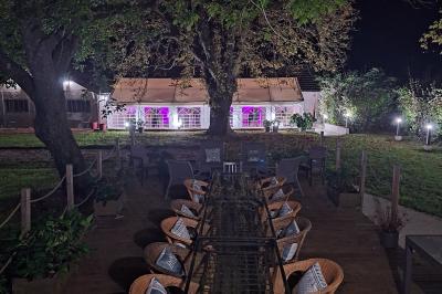 Miniature UNE SOIREE SOUS LE BARNUM QUI COMMENCE Chambre lumineuse avec lit double, fauteuil en bois, baignoire blanche et grande fenêtre donnant sur l'extérieur.