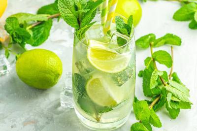 Borne photo interactive éclairée entourée de poteaux dorés et cordons rouges sur un tapis rouge dans une salle lumineuse.