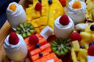 Borne photo interactive éclairée entourée de poteaux dorés et cordons rouges sur un tapis rouge dans une salle lumineuse.