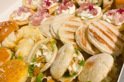 Borne photo interactive éclairée entourée de poteaux dorés et cordons rouges sur un tapis rouge dans une salle lumineuse.