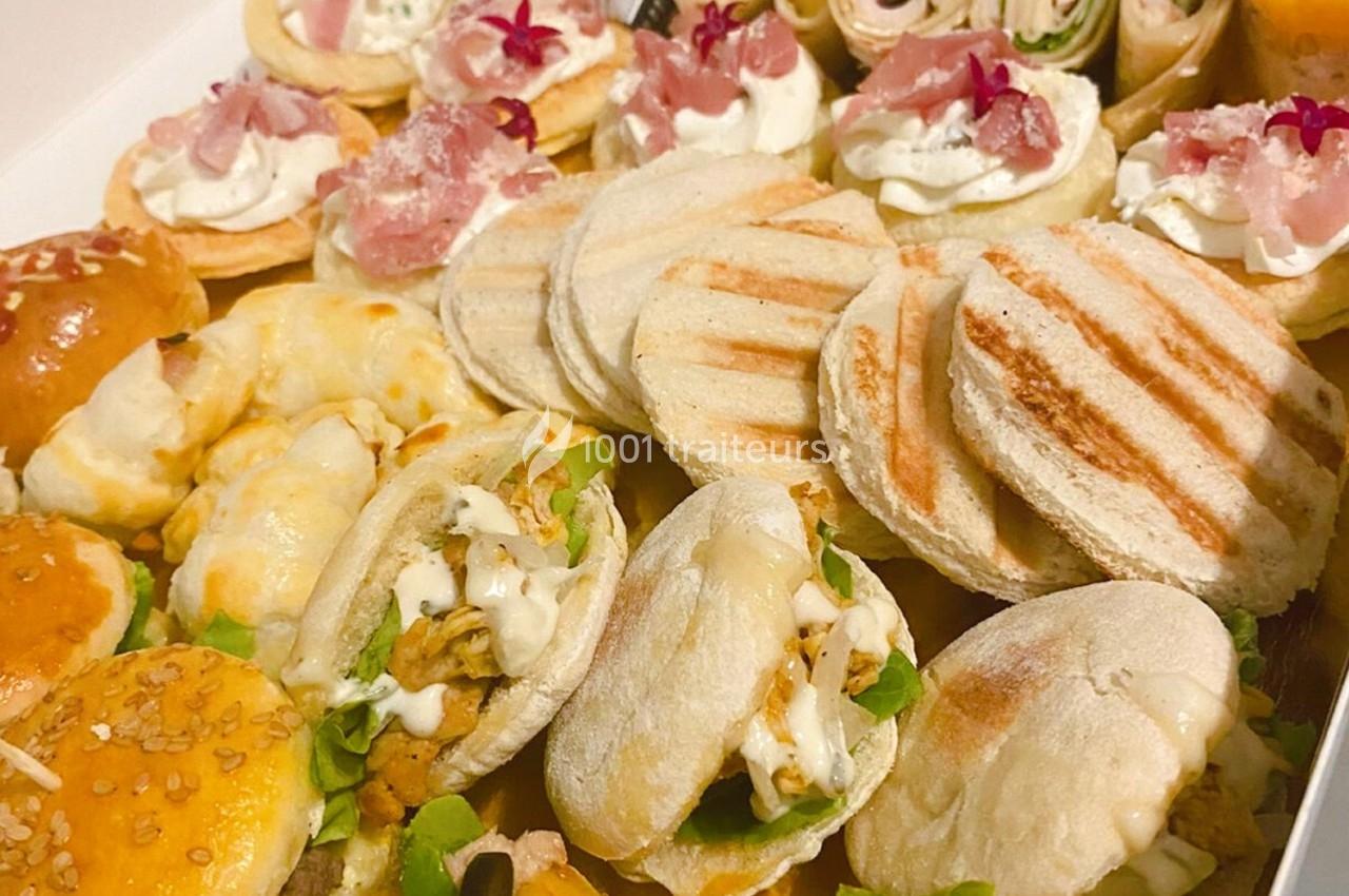 Plateau varié de mini-sandwichs, wraps et bouchées garnies de légumes, viandes et fromages.