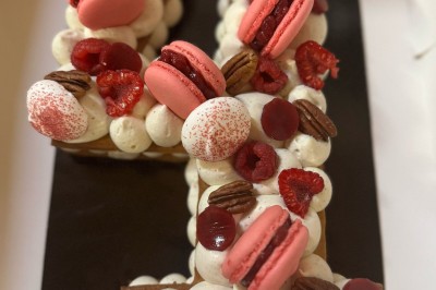 Borne photo interactive éclairée entourée de poteaux dorés et cordons rouges sur un tapis rouge dans une salle lumineuse.