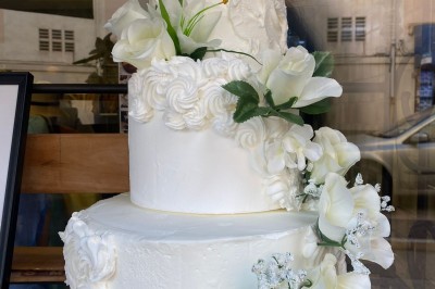 Borne photo interactive éclairée entourée de poteaux dorés et cordons rouges sur un tapis rouge dans une salle lumineuse.