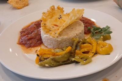 Borne photo interactive éclairée entourée de poteaux dorés et cordons rouges sur un tapis rouge dans une salle lumineuse.